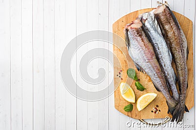 Raw fresh Pollock fish on a wooden Board with lemon Copy space Stock Photo