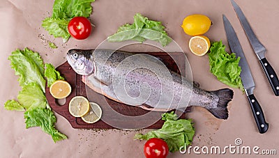 Raw fresh unprepared salmon fish on a wooden board with ingredients for cooking. Stock Photo