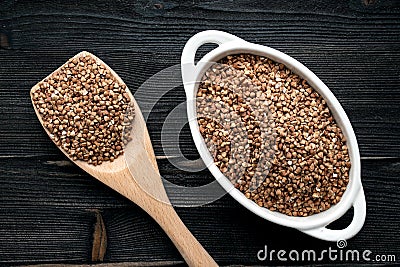 Raw fried buckwheat grains in white bowls - flat lay Stock Photo