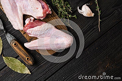 Raw goose wings, on black wooden table background, top view flat lay, with copy space for text Stock Photo