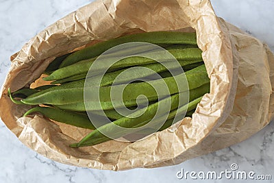 Raw green beans in a brown paper bag. Eco friendly recycling packaging Stock Photo