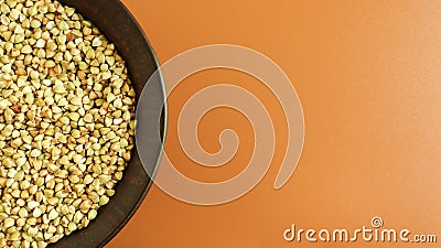 Raw green buckwheat in a brown clay plate on a brown background. Vegan organic food concept. The concept of diet, weight loss, Stock Photo