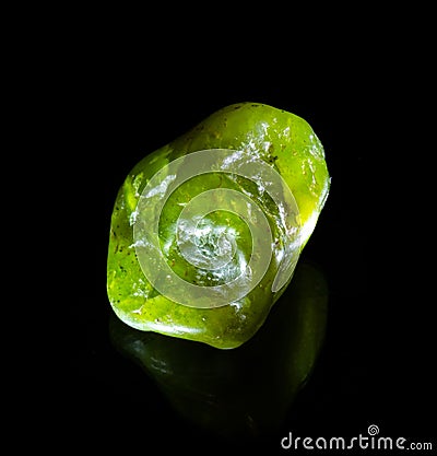 Raw green nephritis jade mineral nugget from Austria isolated on black background. For geology mineralogy magazines websites Editorial Stock Photo