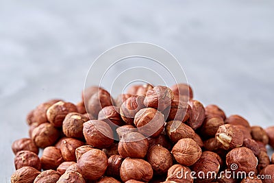 Raw hazelnut on heap isolated on white background, selective focus, shallow depth of field Stock Photo