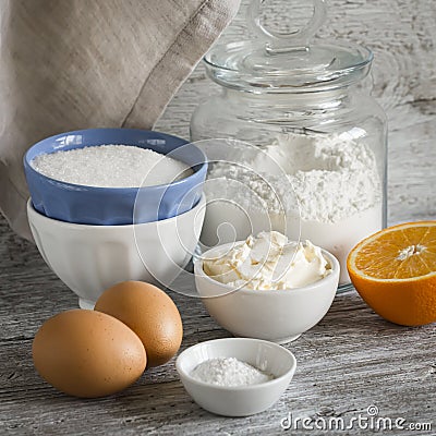 Raw ingredients - flour, eggs, butter, sugar, orange - to cook orange cake. Ingredients for baking. Stock Photo