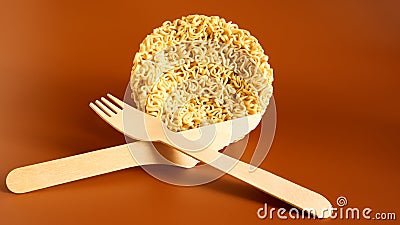 Raw instant noodles in the shape of a circle with a wooden disposable fork. pasta, for the preparation of which it is enough to Stock Photo