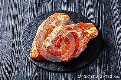 Raw marinated pork chops on a plate Stock Photo