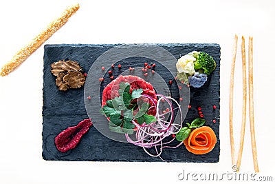 Raw meat carpaccio composition on a slate board Stock Photo