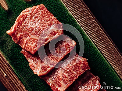 Raw meat cuts artistically arranged on a green plate Stock Photo