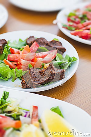 Raw meatballs made with Turkish bulgur on a white serving plate, cigkofte Stock Photo