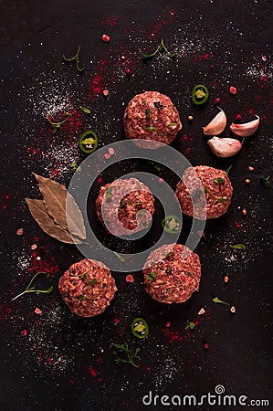 Raw meatballs, with micro greenery, with spices , on a black background , top view, homemade, no people, Stock Photo