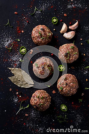 Raw meatballs, with micro greenery, with spices , on a black background , top view, homemade, no people, Stock Photo