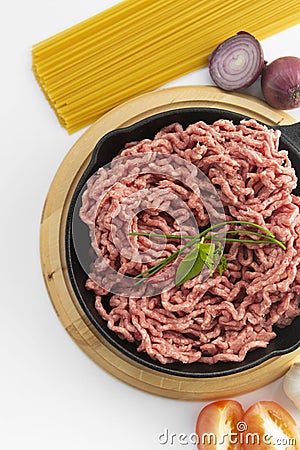 Raw micned beef uncooked meat with spaghetti basil onions white bacground spaghetti bolognaise top view Stock Photo