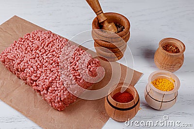 Raw minced meat beef with various spices on a wooden board Stock Photo