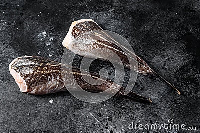 Raw monkfish without a head. Black background. Top view Stock Photo