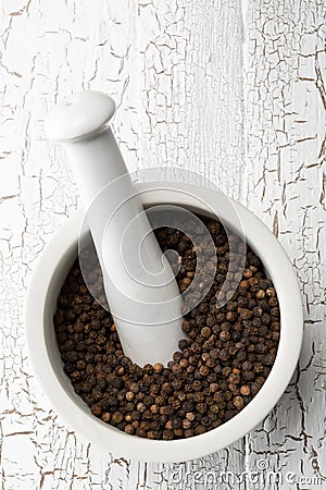 Raw, natural, unprocessed black pepper peppercorns in mortar Stock Photo