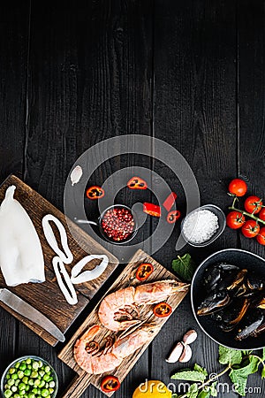 Raw paella ingredients on black wooden surface, top view with space for text Stock Photo