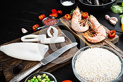 Raw paella ingredients on black wooden table Stock Photo