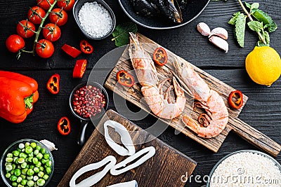 Raw paella ingredients over black wooden table, top view Stock Photo