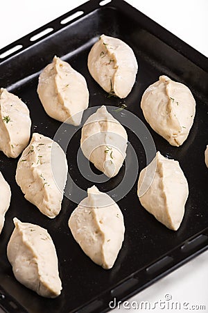 Raw pies lying on a steel baking sheet. Close-up view Stock Photo