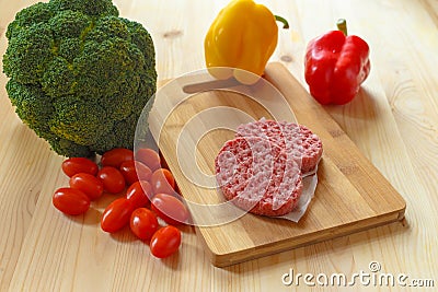 Raw patties of minced meat on a wooden board Stock Photo