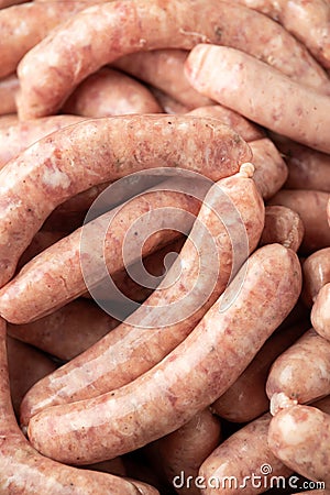 Raw pork chipolata sausage in cast iron skillet frying pan Stock Photo