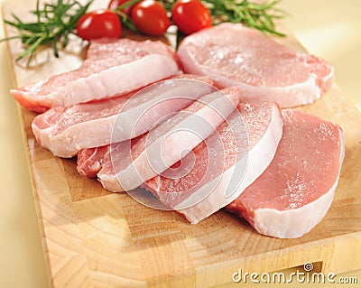 Raw pork chops. Arrangement on a cutting board. Stock Photo