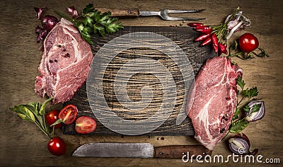 Raw pork meat chops with kitchen tools, fresh seasoning and ingredients for cooking on rustic wooden background, top view, frame. Stock Photo