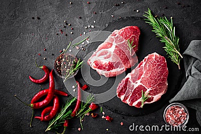 Raw pork meat. Fresh steaks on slate board on black background Stock Photo