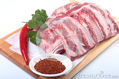 Raw pork ribs with herbs and spices on wooden board. Ready for cooking. Stock Photo