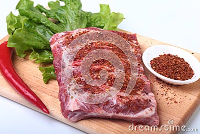 Raw pork ribs with herbs and spices on wooden board. Ready for cooking. Stock Photo