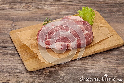 Raw pork steak over wooden board Stock Photo