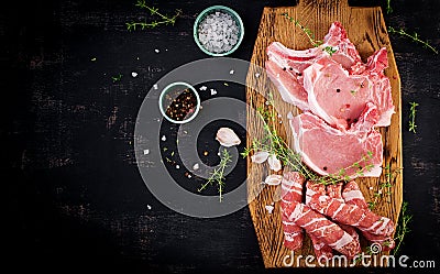 Different types of raw pork meat and chopped sausages Ð¾n the dark table. Stock Photo