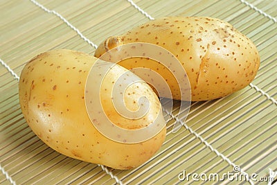 Raw potato on bamboo mat Stock Photo