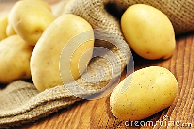 Raw potatoes in jute sack, selective focus Stock Photo