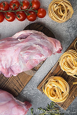 Raw rabbit meat and cooking ingredients stew tagliatelle, on gray stone background, top view flat lay Stock Photo