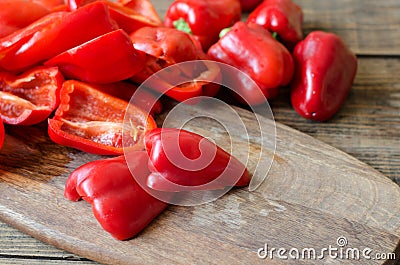 Raw red bell pepper sliced into halves on a wooden background Stock Photo