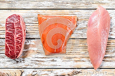 Raw salmon, beef and Turkey. Fresh organic meat. White wooden background. Top view Stock Photo