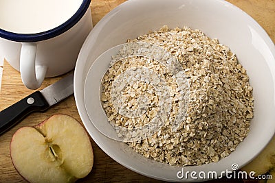 Raw scottish oatmeal, milk in a mug and apple Stock Photo
