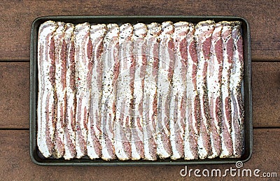 Raw sliced peppercorn bacon in baking sheet Stock Photo