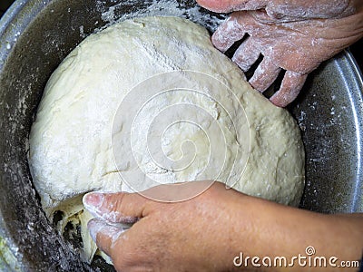 Raw thick dough in the hands of a woman baker. Ready dough for baking in a pan. Test batch. Cook's hands. Stock Photo