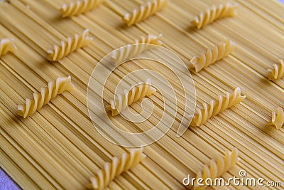 Raw fusilli pasta lies on spaghetti pasta Stock Photo