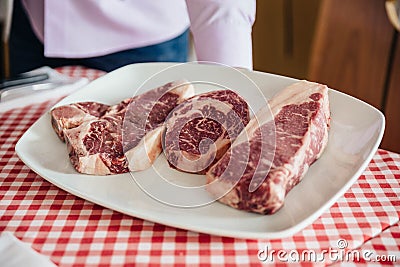 Raw wagyu beef cuts from left to right: T-Bone Steak, Rib Eye and Boneless Top Loin Steak. Stock Photo