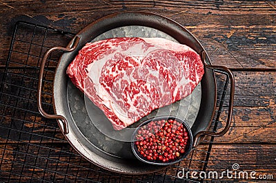 Raw wagyu rib eye beef meat steak in steel tray. Wooden background. Top view Stock Photo