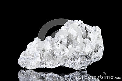 Raw white calcite mineral stone in front of black background Stock Photo