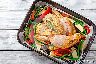 Raw whole chicken with colorful pieces of peppers, potatoes. cl Stock Photo