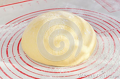 Raw yeast dough on the floured silicone baking mat Stock Photo