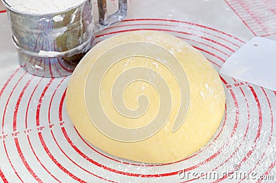 Raw yeast dough on the floured silicone baking mat Stock Photo