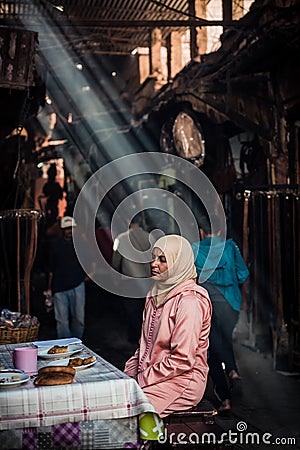 Ray of light. Portrait of an arabian woman sitting at a table as seen in Marrakesh Editorial Stock Photo