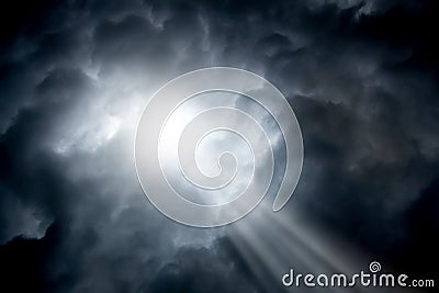 The ray of sunshine breaks through dark stormy clouds. Symbol of Stock Photo